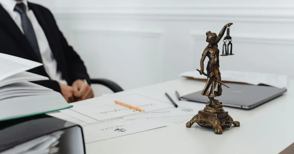 Lady Justice statue on a desk with legal documents