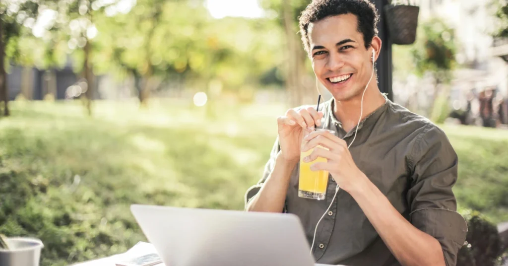 student sitting with laptop in park