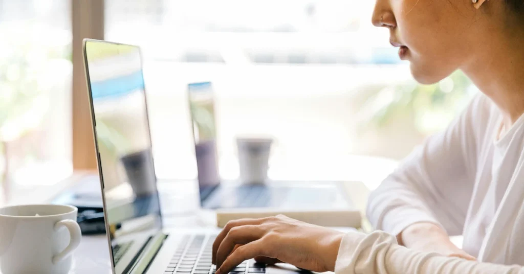 student typing on laptop